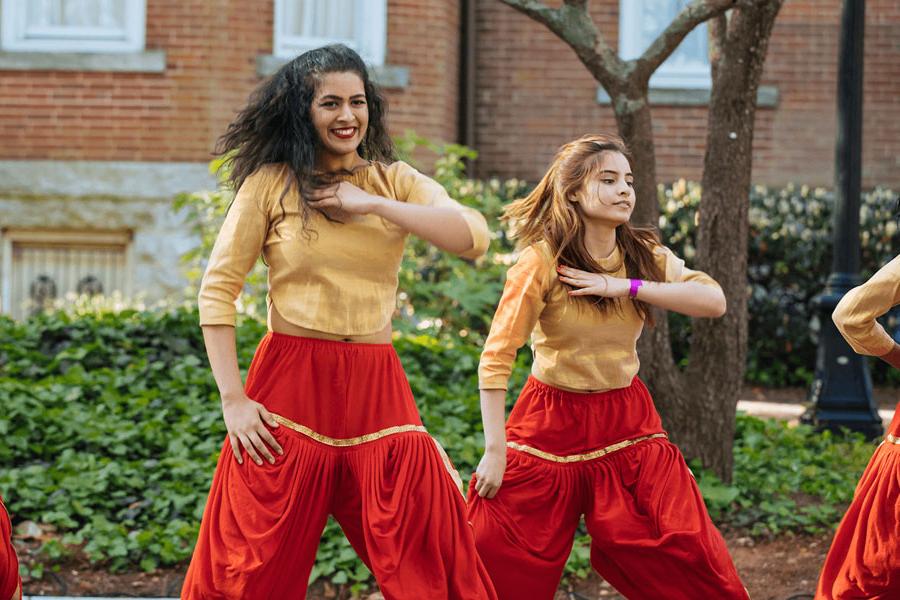 A student bollywood dance team performs outside.