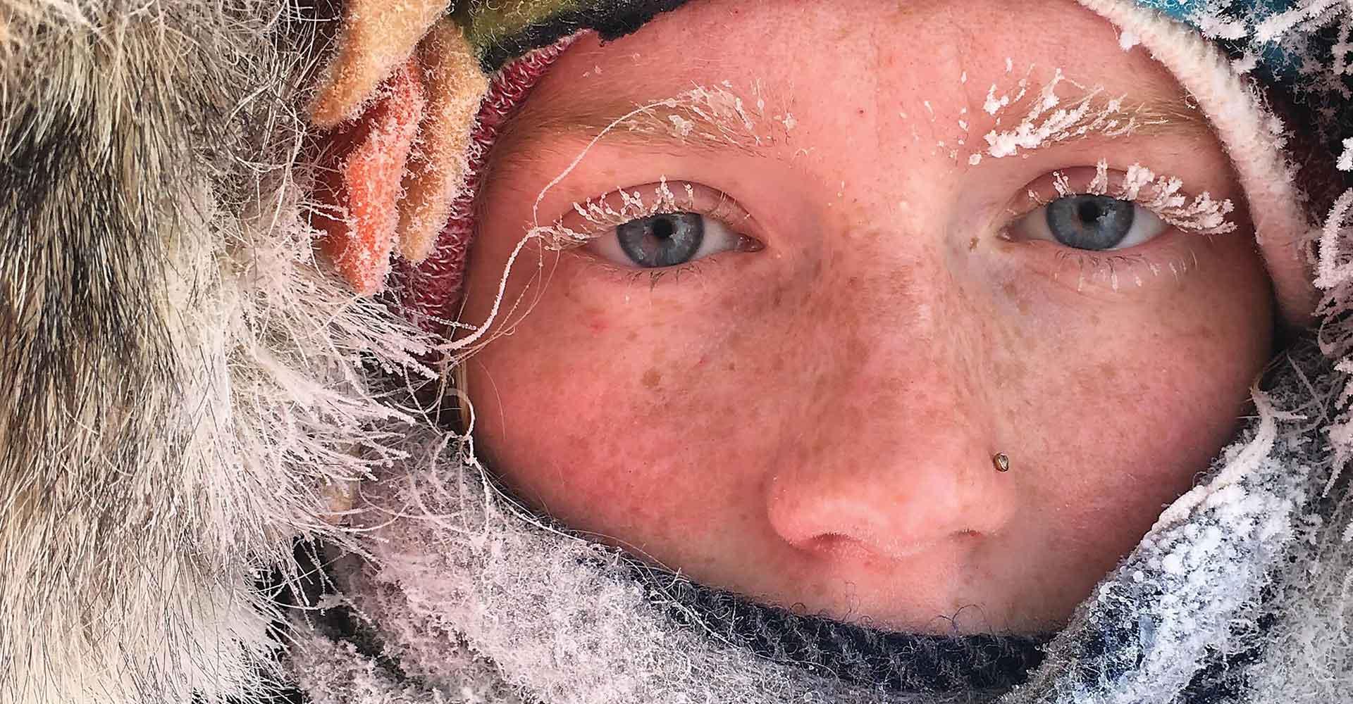 阿格尼斯·斯科特峰会学生的脸部特写，他们穿着大衣，睫毛上结了霜.