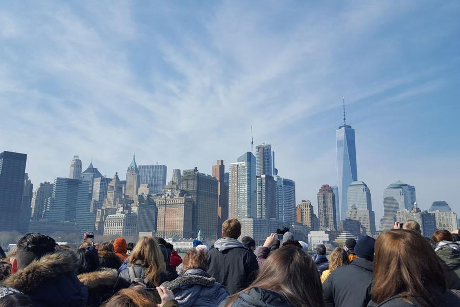 A group of people look at the New York City skyline.